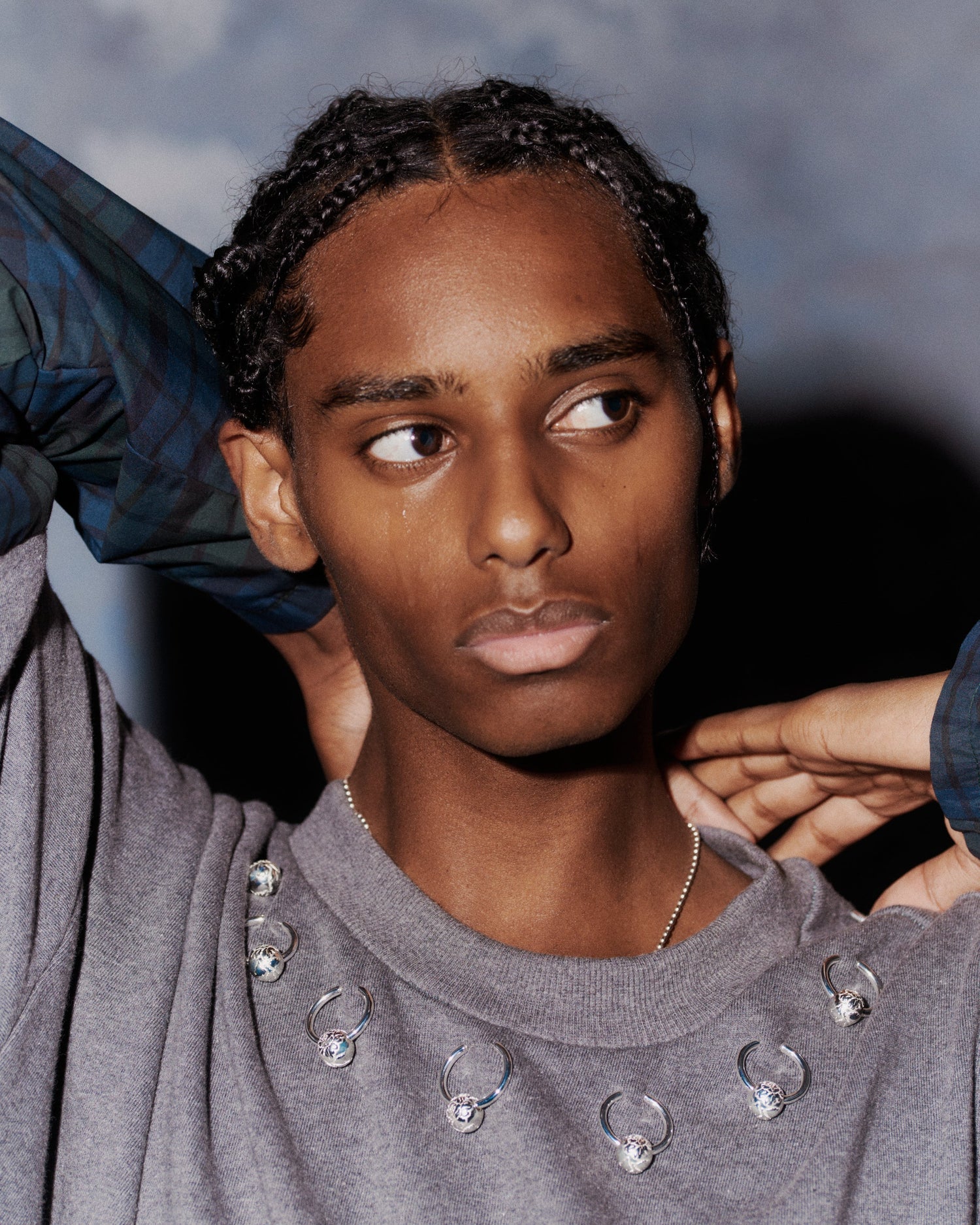 RAKAS Rolf Ekroth x Kalevala kollaboraatio on enemmän kuin koru. Mallilla on päällään harmaa neule, johon on kiinnitetty useita Rakas-koruja.